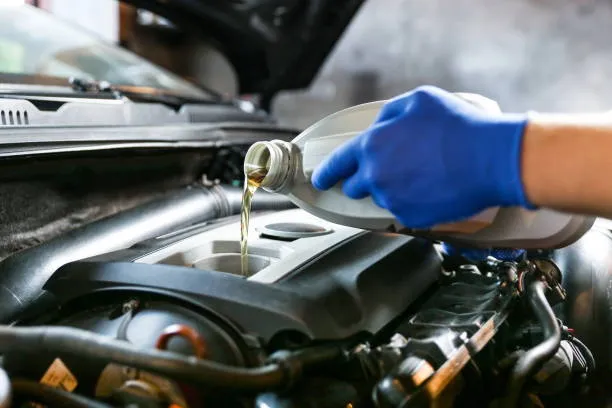 Motora motor yağı dolduran teknisyen
